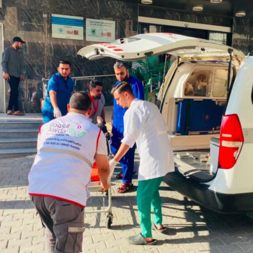 Hulpverleners en een ambulance van het Al-Awda-ziekenhuis