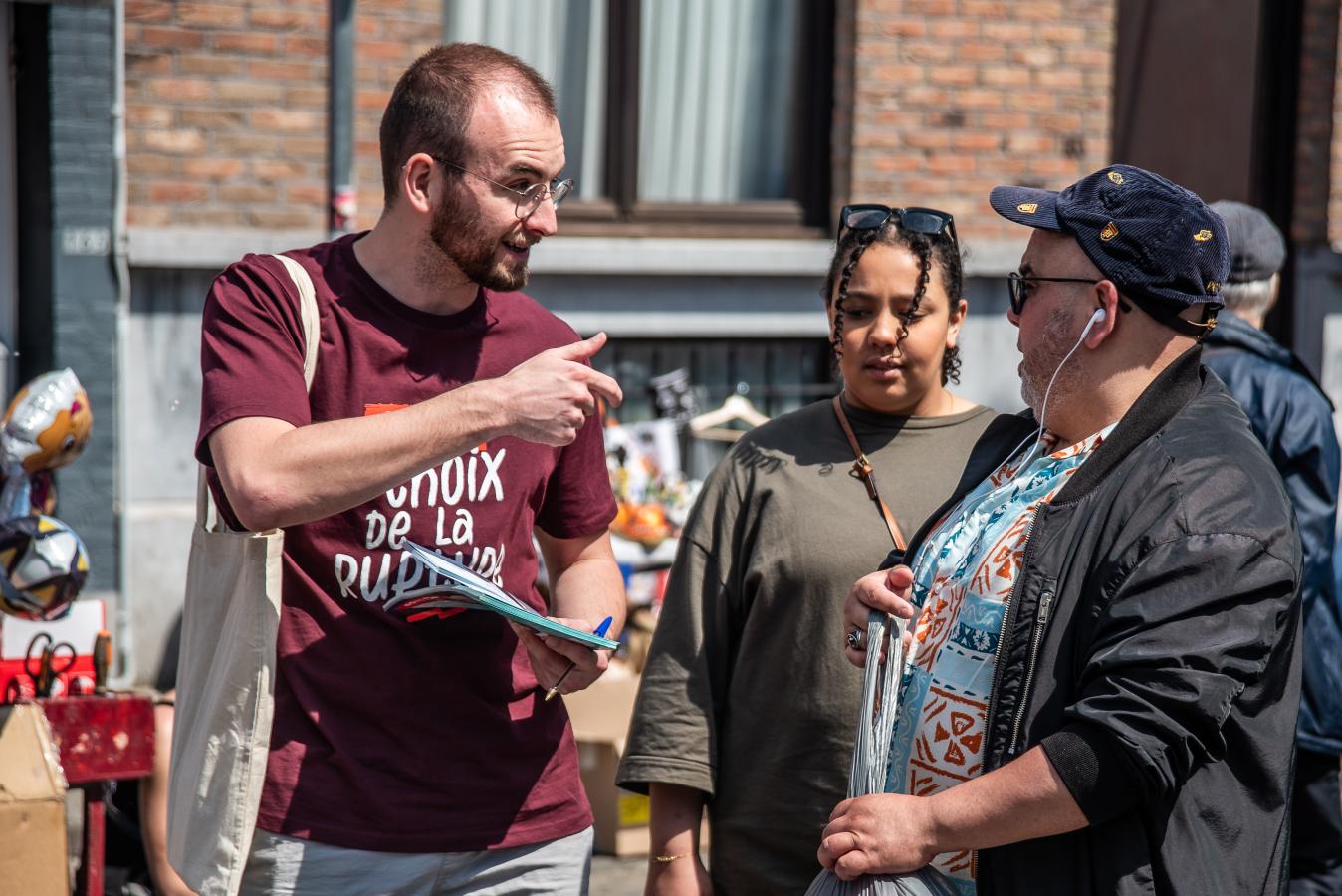 Een militant van de PVDA in gesprek met een vrouw op straat