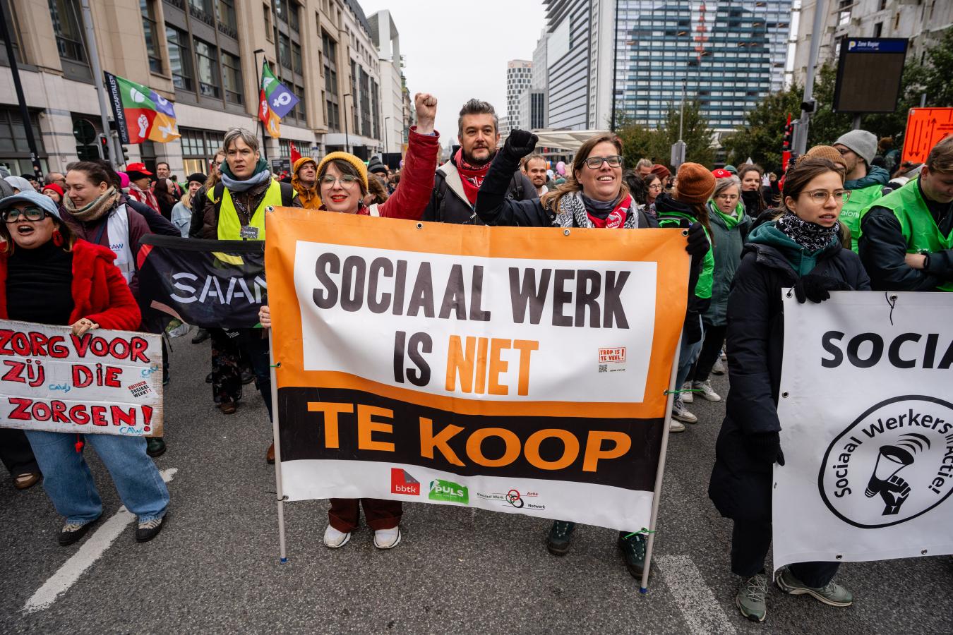 Betogers met een spandoek “Sociaal werk is niet te koop”