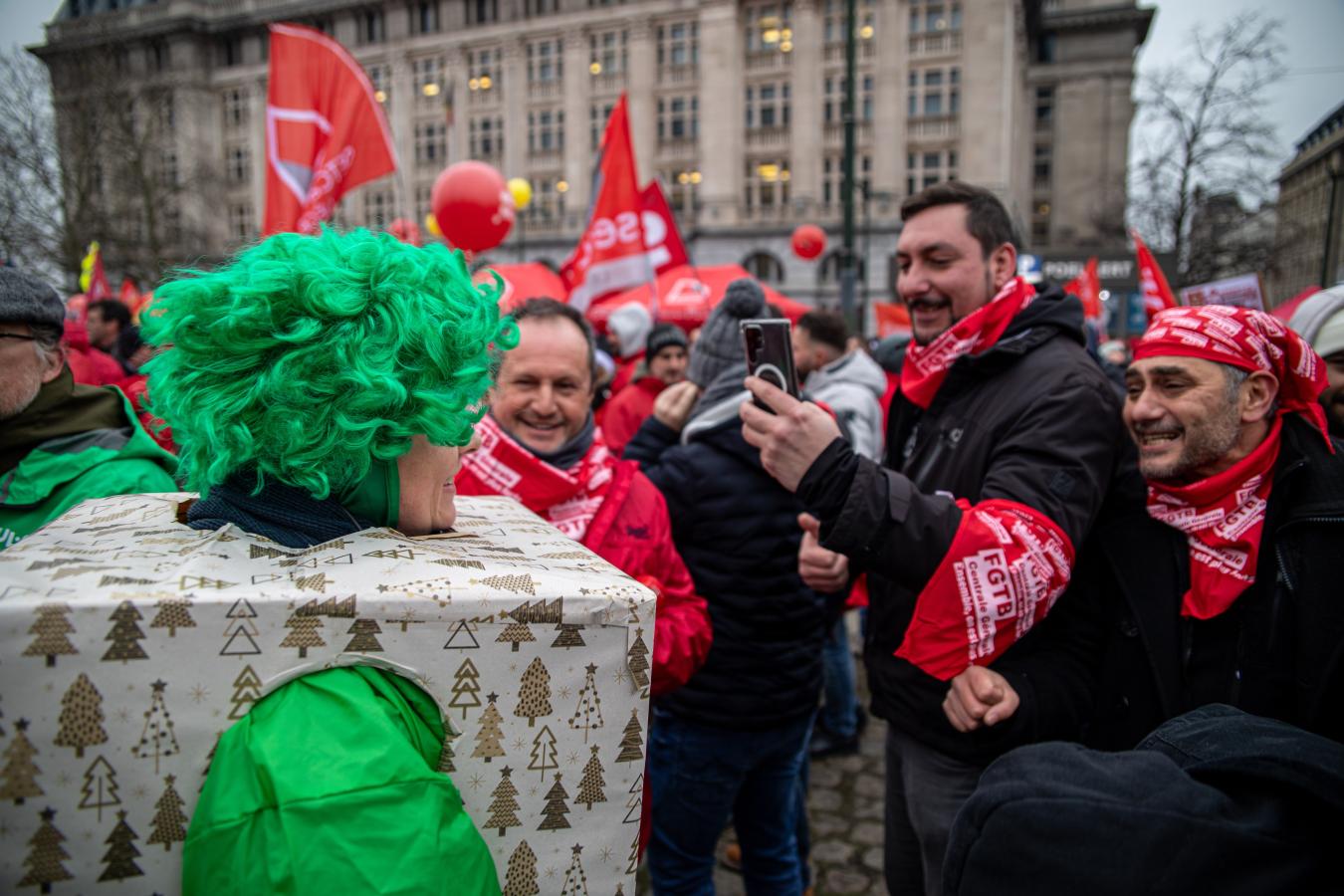 ABVV-syndicalisten nemen een foto van een ACV-militant verkleed als kerstcadeau