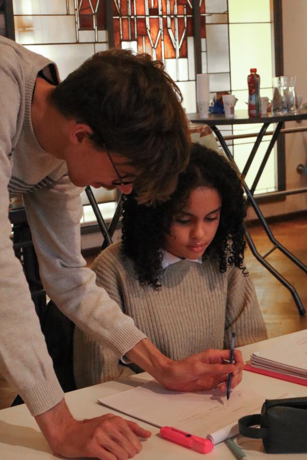 Een vrijwilliger helpt een scholier studeren tijdens de Boostdays van RedFox