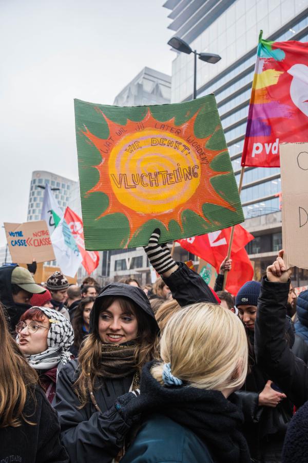 vakbondsbetoging 13 februari: jonge vrouw houdt een bordje omhoog