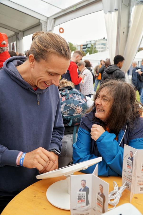 Een man en een vrouw lachend achter een tablet