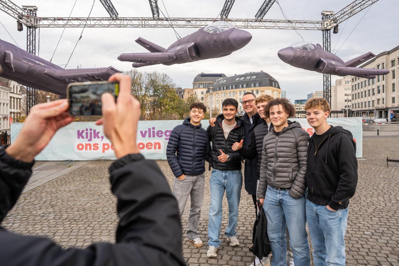 Een groepsfoto waarop jongeren poseren met Raoul Hedebouw