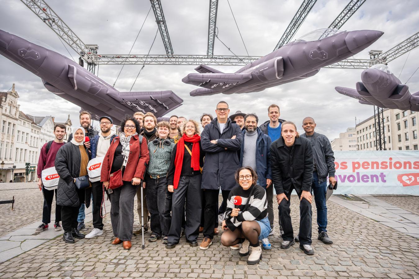 Een groepsfoto onder de drie opblaasbare F-35's. Raoul Hedebouw staat in het midden.