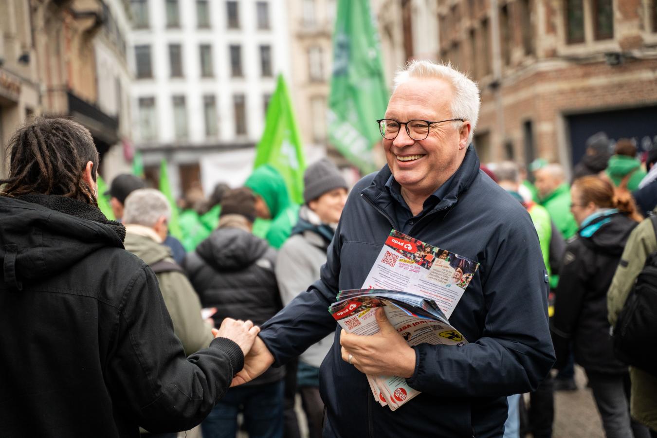 Peter Mertens deelt flyers uit tijdens de actiedag op 10 februari in Antwerpen