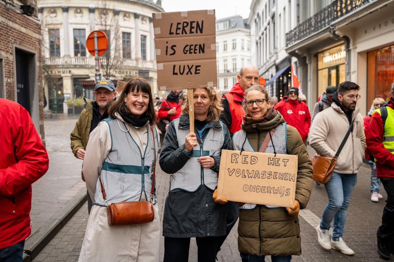 3 leerkrachten met spandoeken tijdens de actiedag op 10 februari in Antwerpen