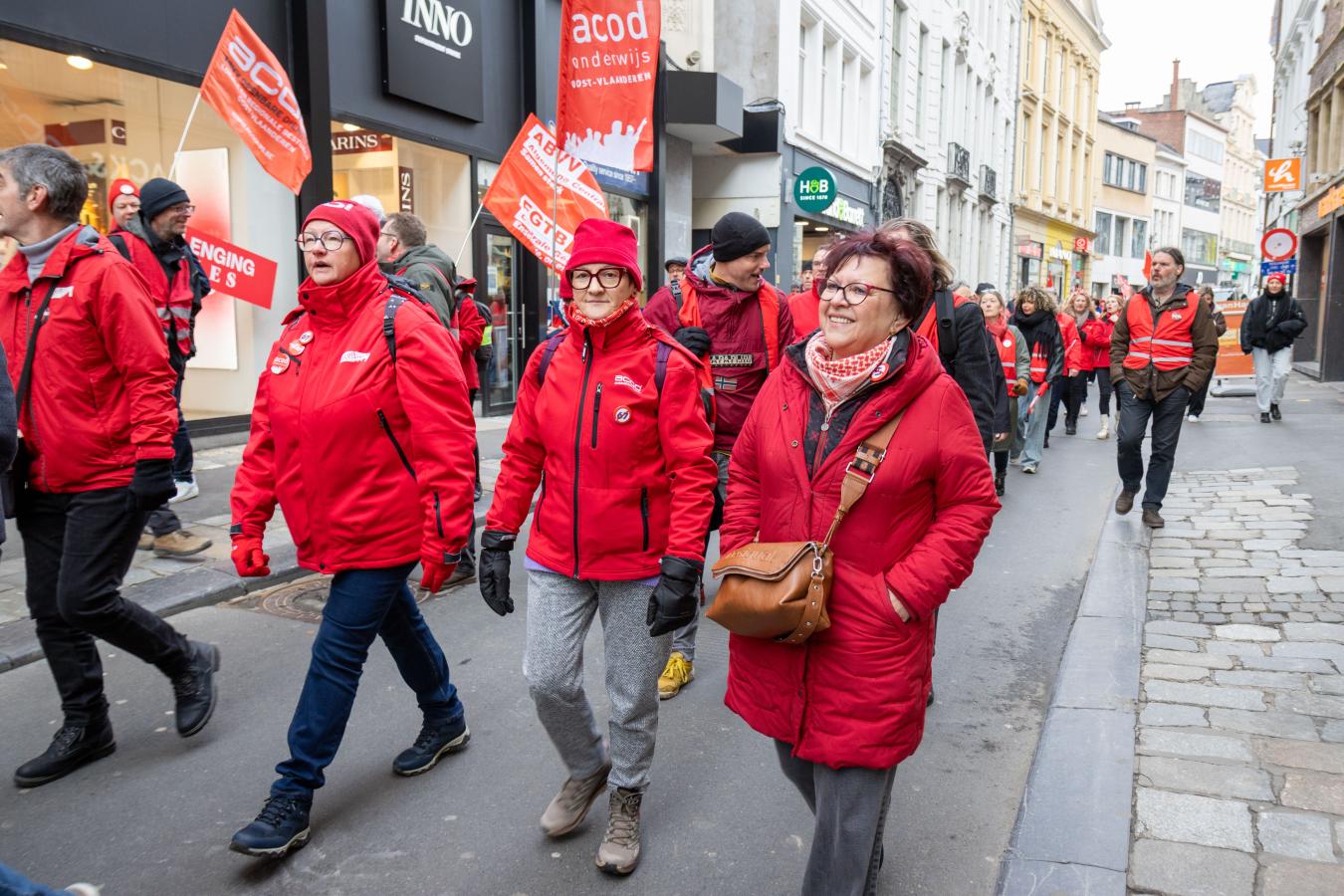 Drie vrouwen in rode vakbondsuitrusting tijdens de provinciale actiedag van 5 februari in Gent