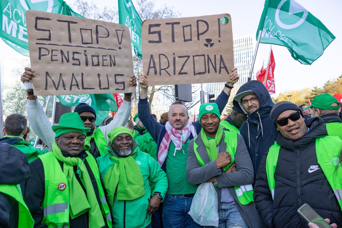 beeld 8: groepje ACV-syndicalisten met bordjes 'stop pensioenmalus' en 'stop Arizona'