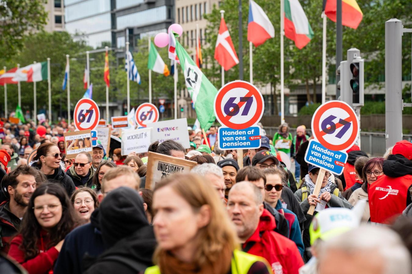 Beeld van een massa betogers tijdens een betoging tegen de regering-De Wever-Rousseau. Op enkele bordjes is te lezen ‘Handen af van ons pensioen’