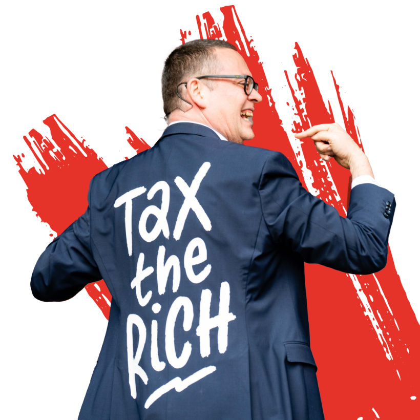 Raoul Hedebouw, président du PTB, avec une veste sur laquelle il est écrit "Tax the rich".