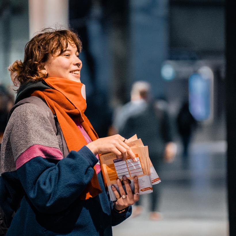 Een militante deelt flyers uit.