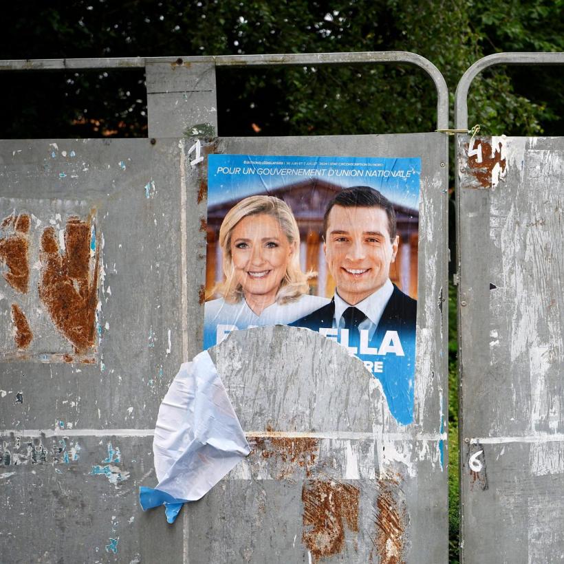 Een verkiezingsaffiche van het RN hangt er verscheurd bij