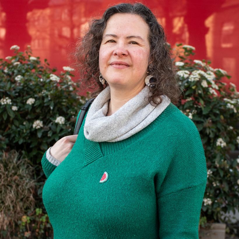 Grijsharige vrouw met een palestina broche.