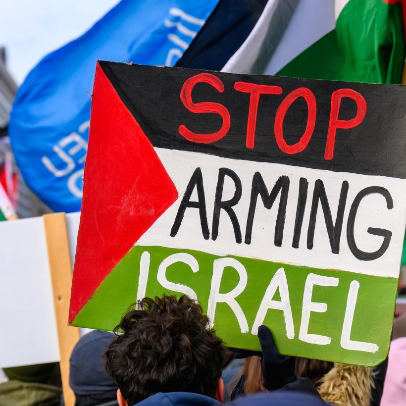 Een bord met de boodschap "Stop arming Israel" in een betoging voor Palestina