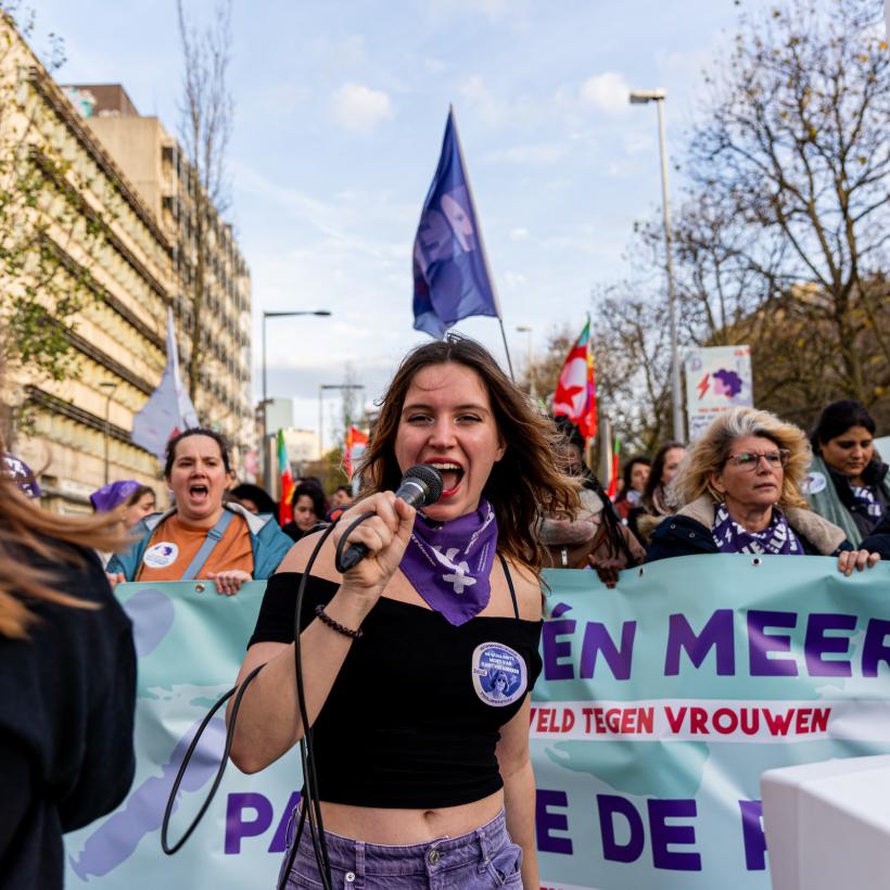 Une jeune femme mène le bloc de Zelle et du PTB lors d'une manifestation contre les violences faites aux femmes.