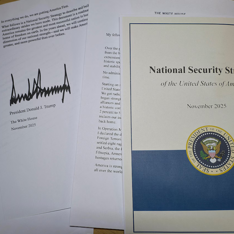 Documents sur une table avec la signature de Trump. Le titre : "National Security Strategy"
