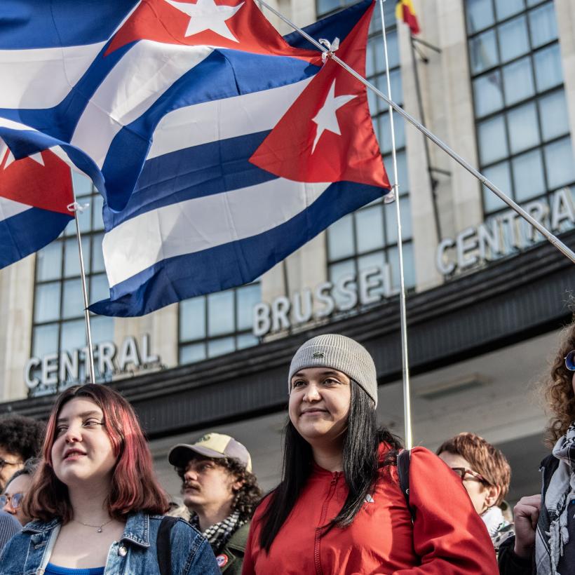 Jonge mensen met Cubaanse vlaggen achter hen op de actie 'Handen af van Cuba' in Brussel op 7 februari 2026.
