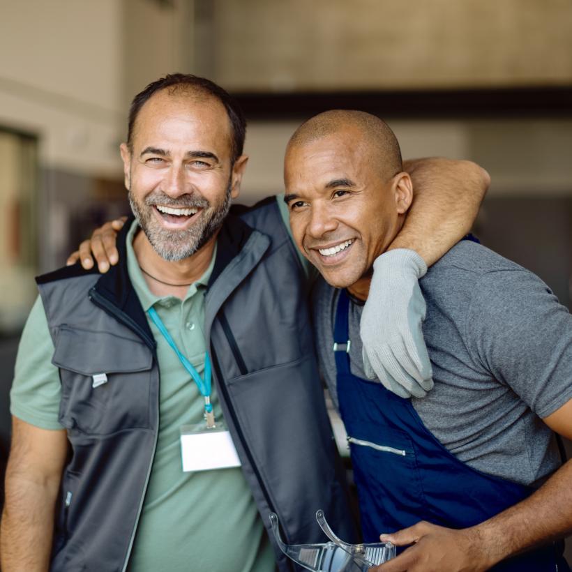 Twee werknemers omhelzen elkaar