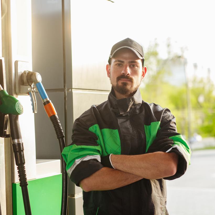 een man staat voor een benzinepomp