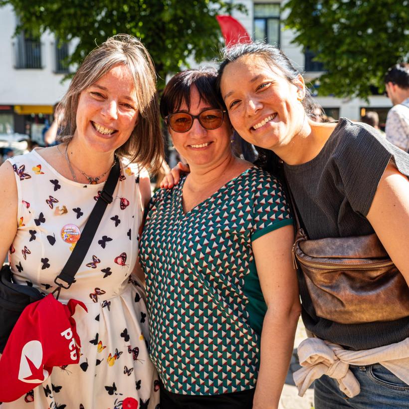3 vrouwelijke leden van de PVDA poseren samen tijdens een evenement 