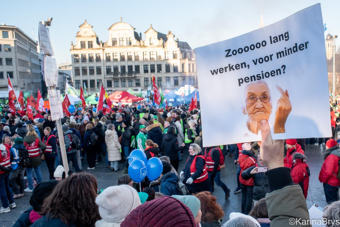 Beeld van menigte op een betoging, met een zichtbare slogan: “Zooooo lang werken voor minder pensioen?”