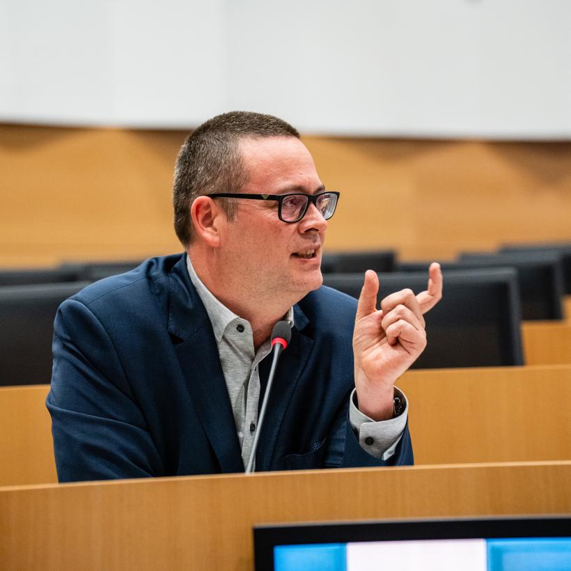 Raoul Hedebouw in het parlement. Hij maakt een gebaar met zijn handen terwijl hij praat.