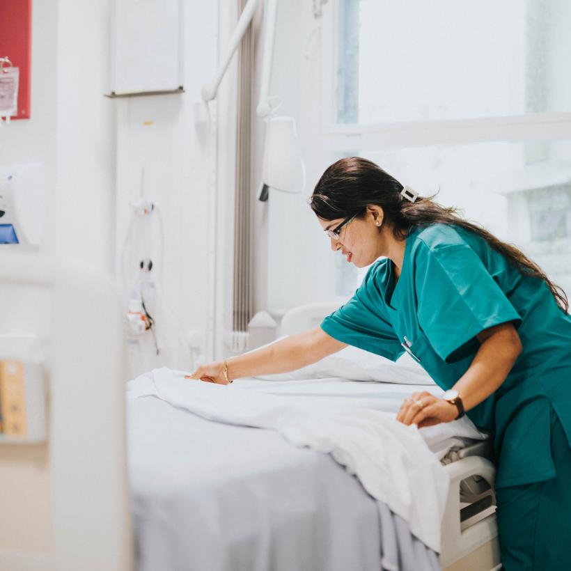 Een verpleegster maakt een bed op