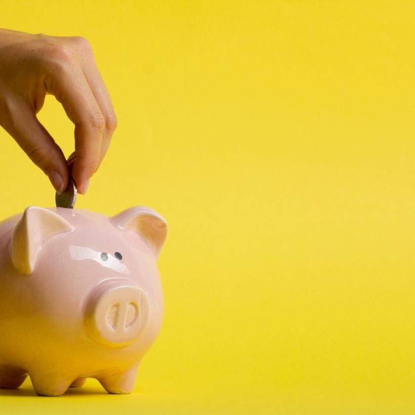 Quelqu'un met une pièce dans une tirelire.