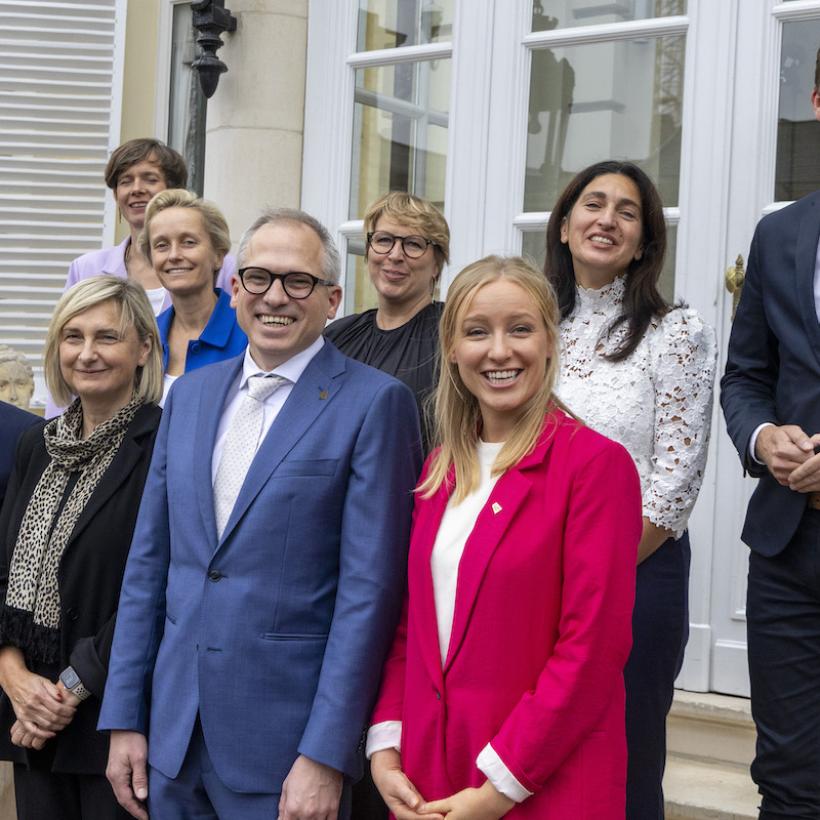 Groepsfoto van de Vlaamse regering met allemaal lachende gezichten
