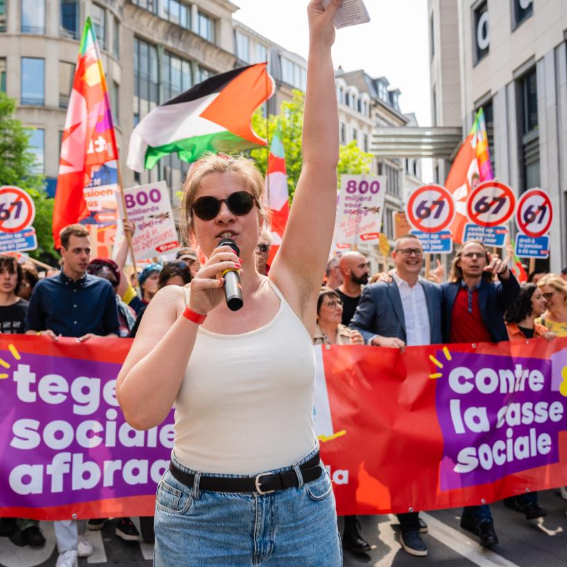 Une jeune femme fait l'animation devant le premier bloc de la Marche contre la casse sociale et pour la paix le 27 avril