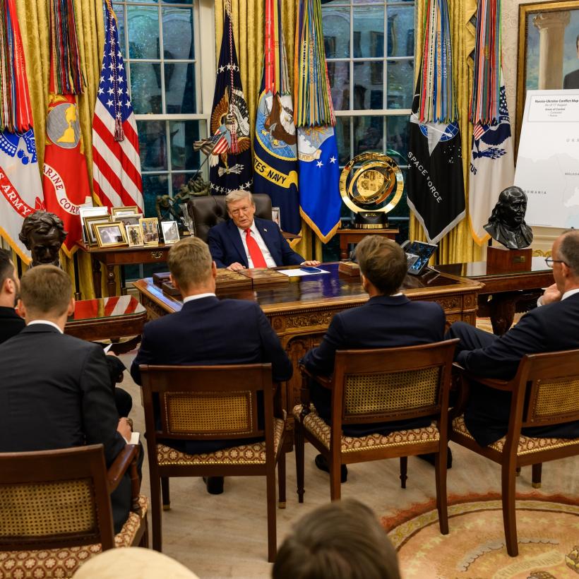 De Amerikaanse president Donald Trump aan zijn schrijftafel, omringd door de Oekraïense president Zelensky, zes Europese leiders en Navo-baas Rutte.