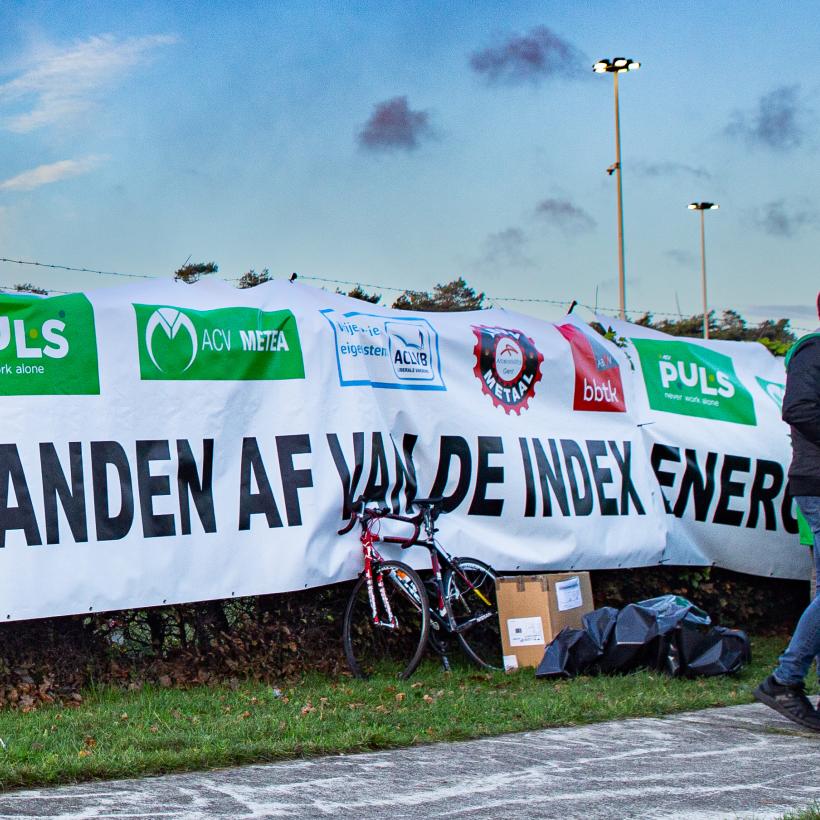 Een vakbondsactie met een spandoek 'Handen af van de index'
