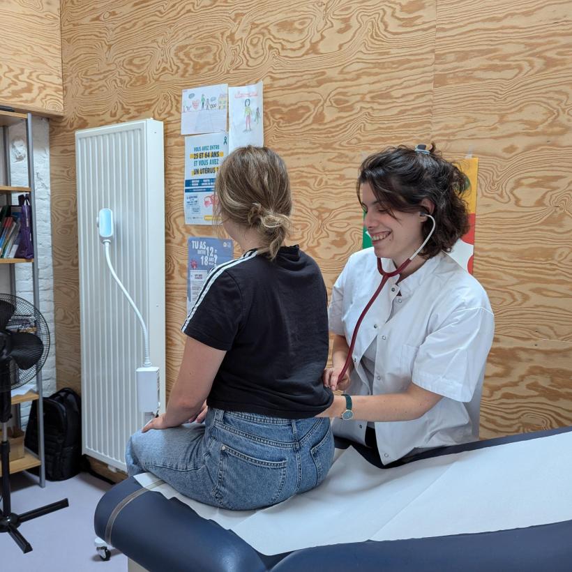 Een dokter van Geneeskunde voor het Volk onderzoekt een jonge patiënt