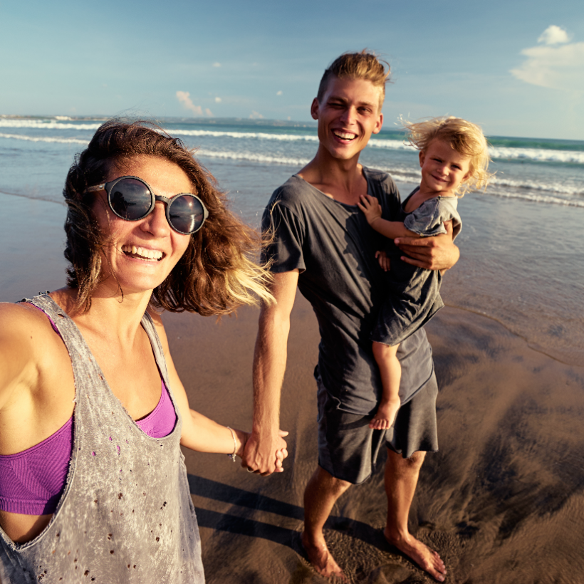 Un homme et une femme sur la plage avec un enfant