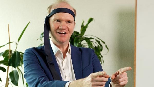 Een man in pak met een stropdas om zijn hoofd.