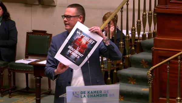 Raoul Hedebouw tijdens zijn tussenkomst in de Kamer. Hij toont een verkiezingsaffiche van Vooruit met daarop: “Vooruit beschermt de index”