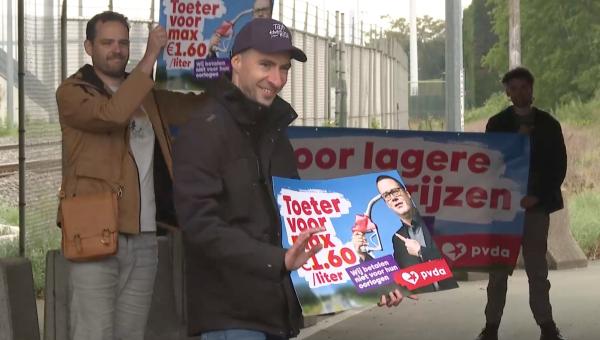 Actievoerders van de PVDA aan de poort van Volvo Cars Gent met borden ‘Toeter voor max. 1,60 euro/liter’. 